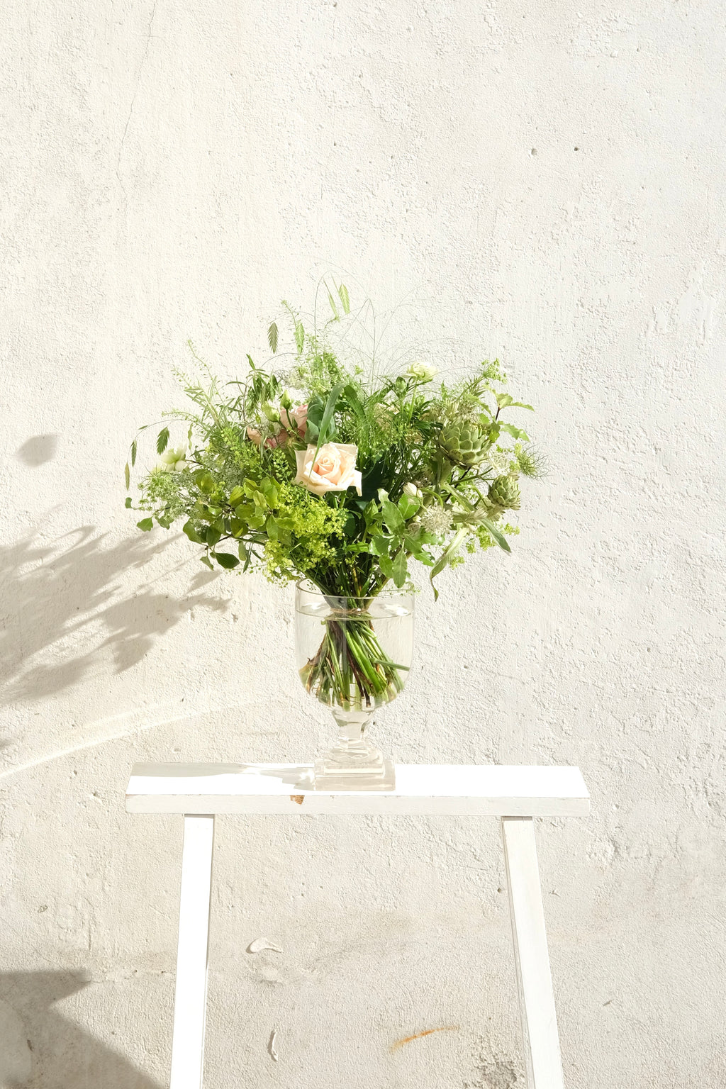 Romantisk lav bundet buket med vilde blomster i lyserøde nuancer