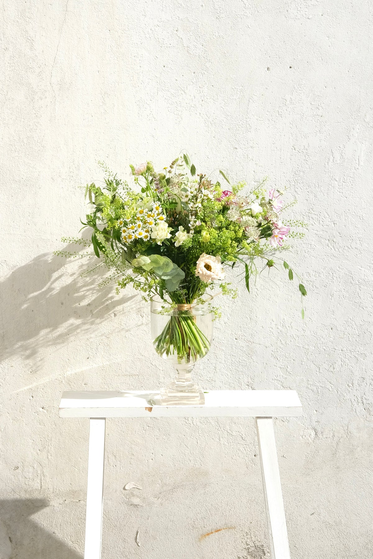 Naturlig vildblomsterbuket med lyserøde og hvide blomster